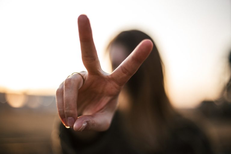 focus photography of woman hand with two fingers