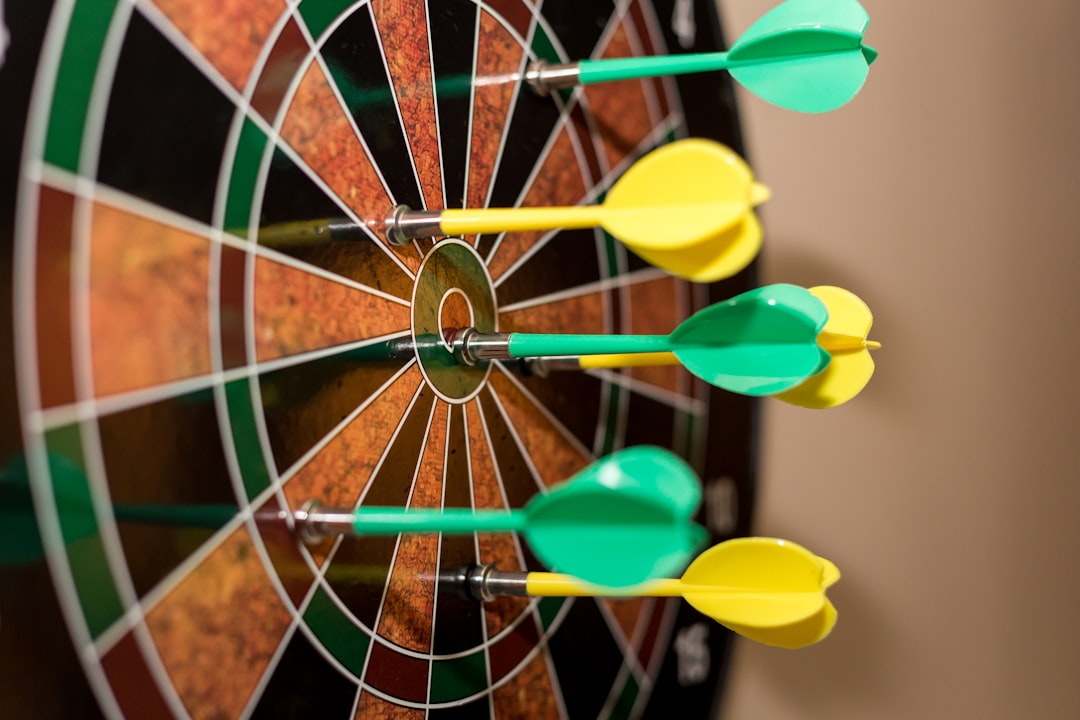 Close up of magnetic darts on dartboard by Games Like green, red, and yellow dartboard